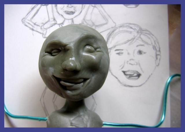 Sculpted face of boy sculpture next to sketch of the face