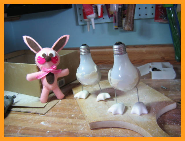 Ralphie the bunny next to work-in-progress light bulb penguin sculptures